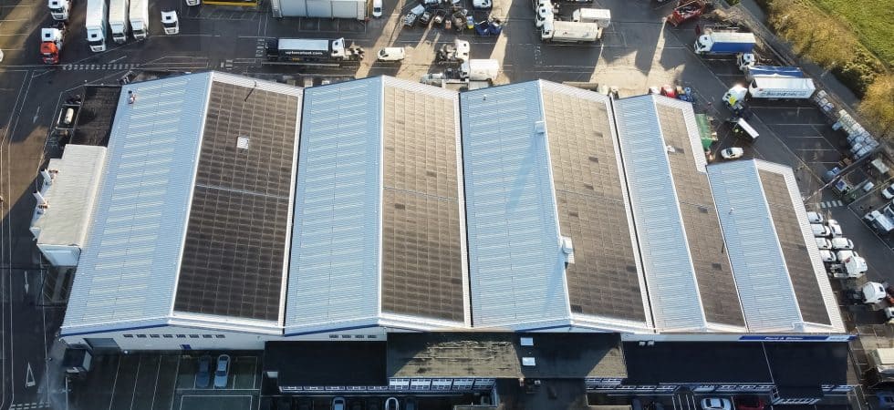 A drone shot of a factory showing the solar panels on the roof.